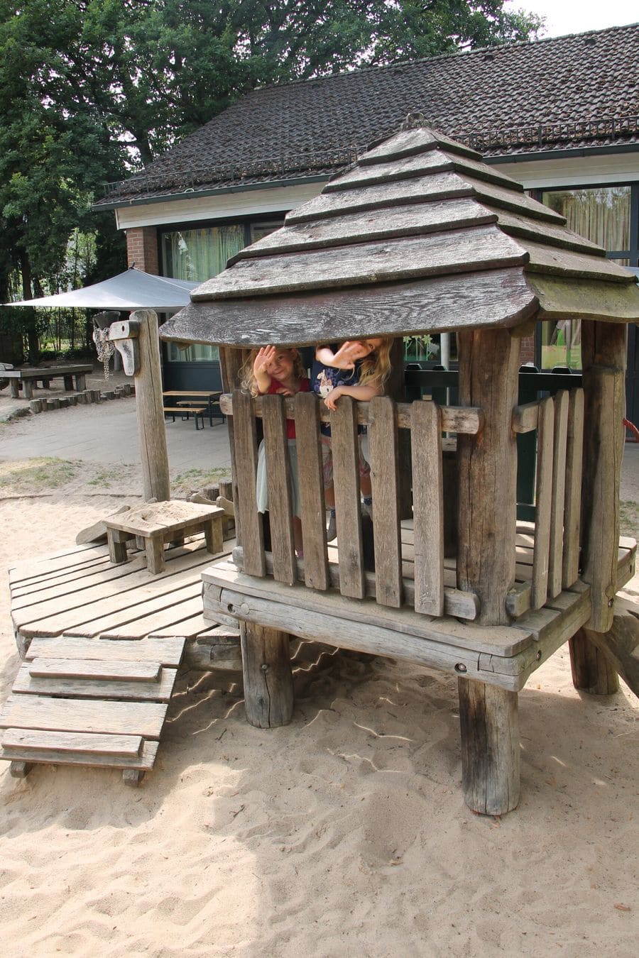 Ein hölzerner Bollerwagen im Garten des Kindergartens.